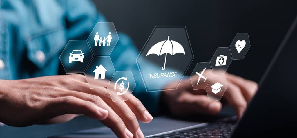 Close-up of hands typing on a laptop, with digital icons representing various insurance types like health, auto, and home hovering above.
